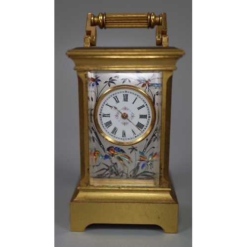 73 - Miniature gilt brass carriage clock with silvered and enamelled face and side panels decorated with ... 