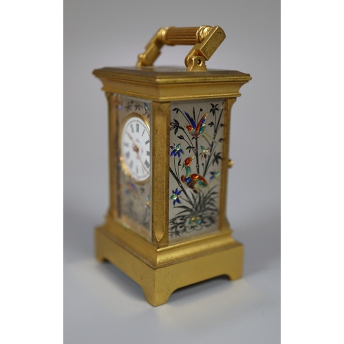 73 - Miniature gilt brass carriage clock with silvered and enamelled face and side panels decorated with ... 