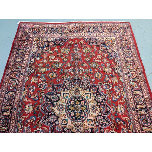 436 - Red ground Persian Mashad carpet having floral medallion to the centre.  300x197cm approx.   (B.P. 2... 