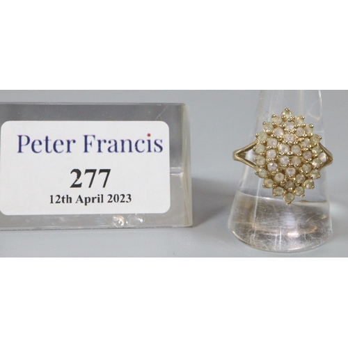 277 - 9ct gold dress ring set with a cluster of white stones.  Ring size R&1/2.  Approx weight 4.6 grams.
... 