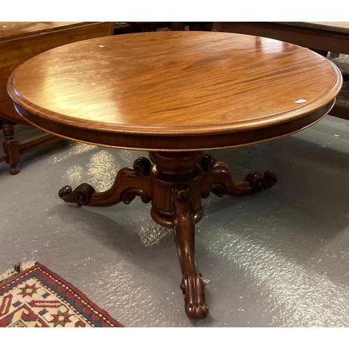 555 - 19th century mahogany tilt top centre table on ornately carved tri form base.  (B.P. 21% + VAT)