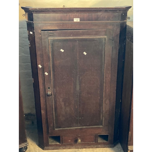 602 - Early 19th oak hanging corner cupboard with blind panelled door revealing shaped shelves to the inte... 