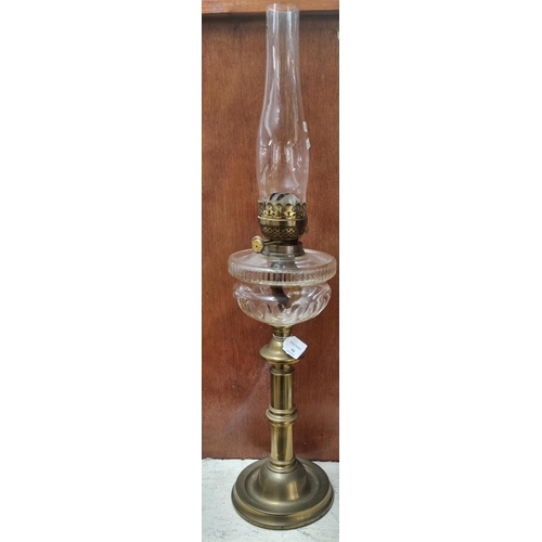 104 - Early 20th Century double oil burner lamp, having clear glass chimney above a clear glass reservoir ... 