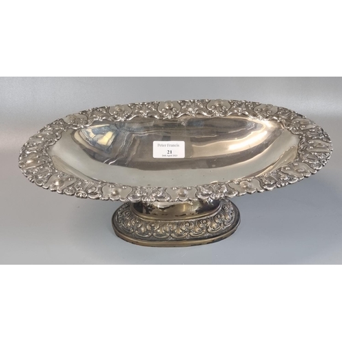 21 - Indian white metal pedestal bowl of oval form ornately embossed with swags and foliage.  33x22x10cm ... 