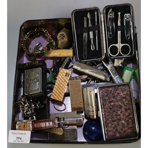 194 - Tin box of oddments, to include: lighters, scissors, costume bracelet etc.  (B.P. 21% + VAT)