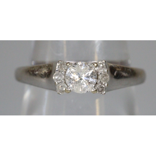 244 - Diamond solitaire ring set in 18ct white gold with three diamonds set to either side.  Ring size P 1... 