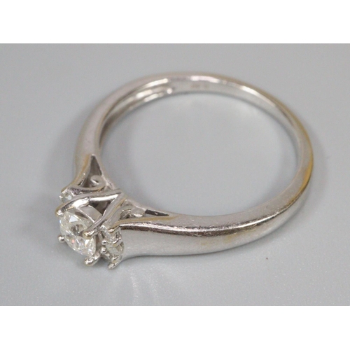 244 - Diamond solitaire ring set in 18ct white gold with three diamonds set to either side.  Ring size P 1... 