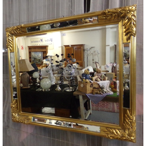 495 - Modern gilt framed mirror of rectangular form with mirrored glass panels and moulded flower head and... 