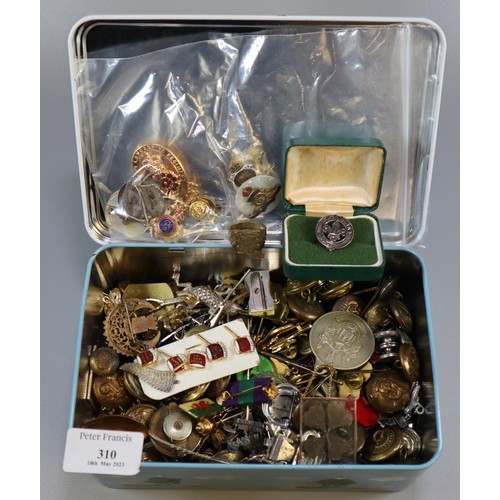 310 - Metal tin containing a large collection of Military and other buttons, pin badges, enamel badges, cr... 