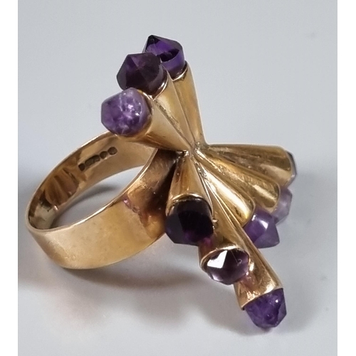 232 - 9ct gold modernist ring with purple stones.  10.8g approx.  Ring size O.   (B.P. 21% + VAT)