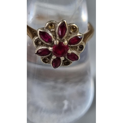 256 - 9ct gold purple stone flower head ring.  3g approx.  Ring size M 1/2.  (B.P. 21% + VAT)