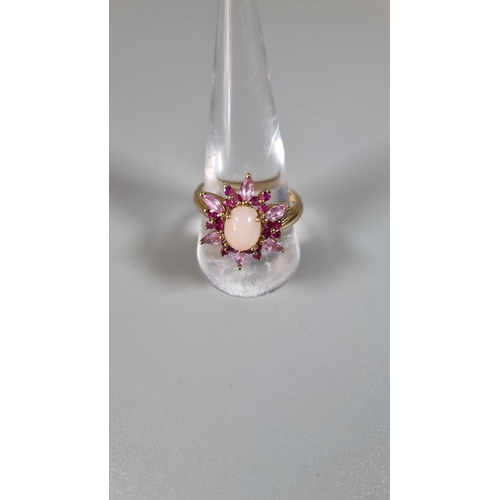 263 - 9ct gold pink stone flower head ring with central cabochon stone.  Ring size T.     (B.P. 21% + VAT)