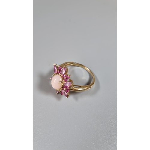 263 - 9ct gold pink stone flower head ring with central cabochon stone.  Ring size T.     (B.P. 21% + VAT)