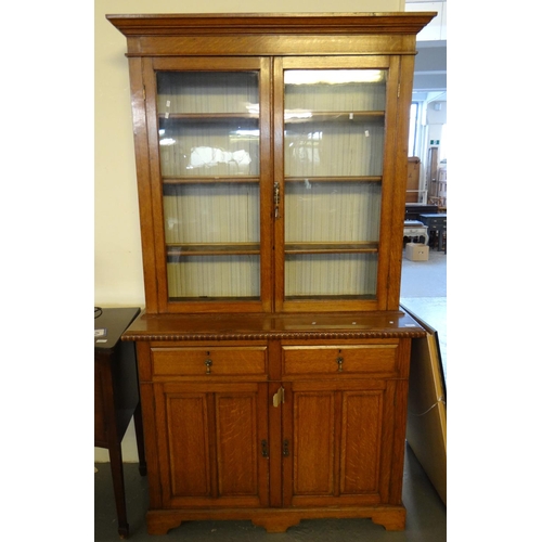 492 - Late 19th early 20th century pale oak two stage two door cabinet back bookcase, the moulded cornice ... 