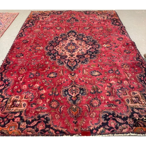 546 - Red ground Persian Mashad carpet decorated with flowers and foliage.  300x205cm approx.   (B.P. 21% ... 