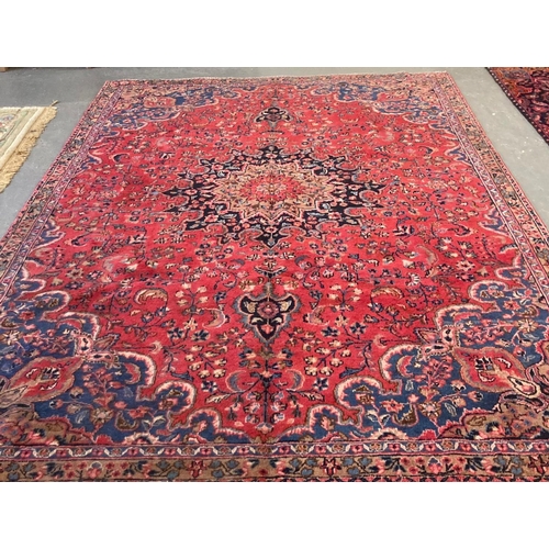 547 - Red and blue ground vintage Persian carpet, overall decorated with flowers and foliage.  310x220cm a... 