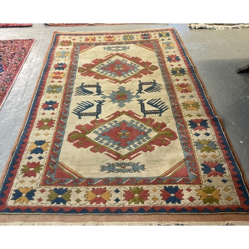 551 - 20th century Turkish multi-coloured beige ground carpet decorated with three lozenge medallions to t... 