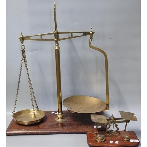 88 - Pair of early 20th century brass shop balance scales with brass pans on mahogany base together with ... 