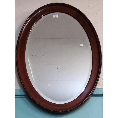 183 - Mahogany framed oval bevelled mirror.  (B.P. 21% + VAT)