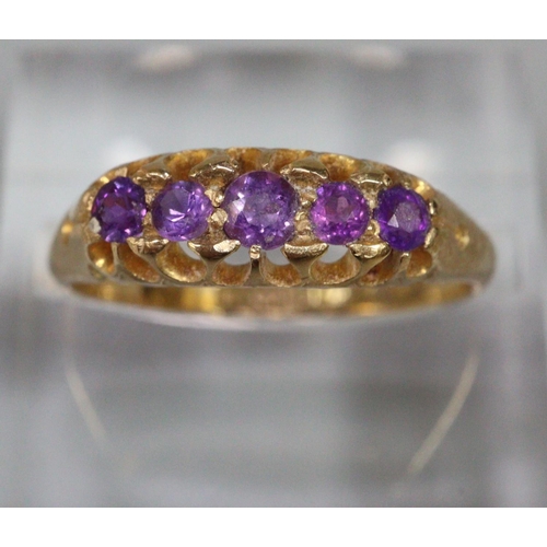 291 - 18ct gold purple five stone dress ring.  Size M1/2.  2.9g approx.  (B.P. 21% + VAT)