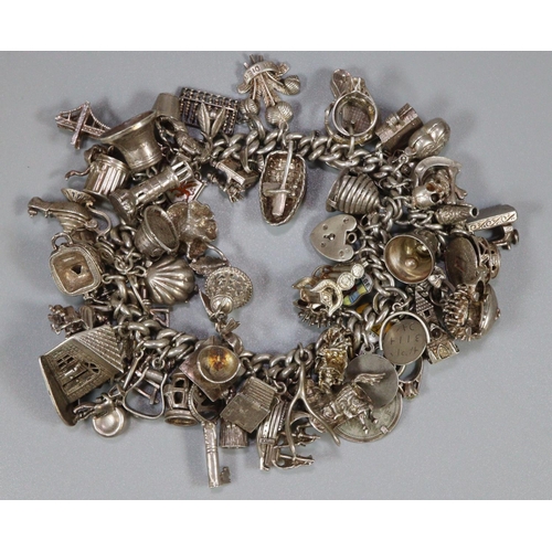 302 - Silver charm bracelet with a large quantity of charms.  7.1 troy oz approx.  (B.P. 21% + VAT)