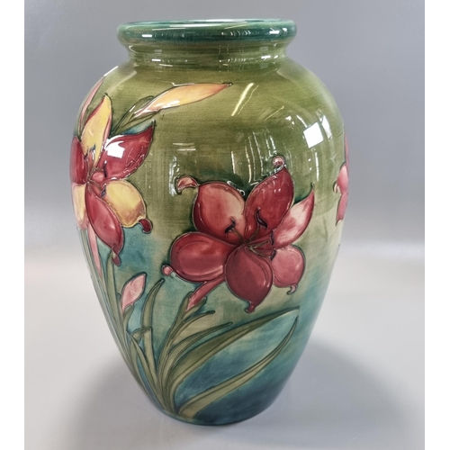 156 - Mid century Moorcroft pottery tube lined 'African Lily' vase on a green ground, of baluster form, im... 