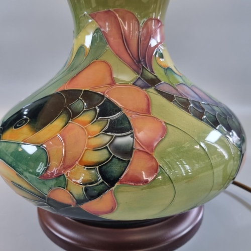 157 - Modern Moorcroft tube-lined Carp design table lamp, of baluster form, standing on a wooden base.  Th... 