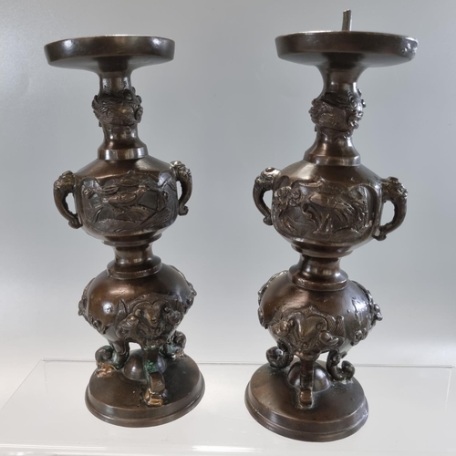 177 - Pair of Japanese bronze tripod candlesticks with panels of birds in branches and bull's head at the ... 