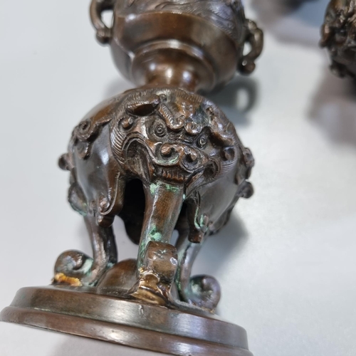 177 - Pair of Japanese bronze tripod candlesticks with panels of birds in branches and bull's head at the ... 