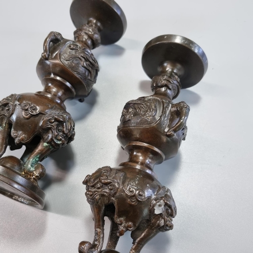 177 - Pair of Japanese bronze tripod candlesticks with panels of birds in branches and bull's head at the ... 