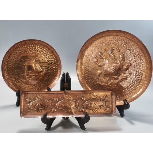 180 - Three Arts & Crafts repoussé decorated Newlyn copper items to include: fish pen tray 26x7cm approx, ... 