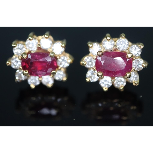 278 - Pair of 18ct gold diamond and ruby earrings, the central ruby surrounded by ten diamonds, together w... 