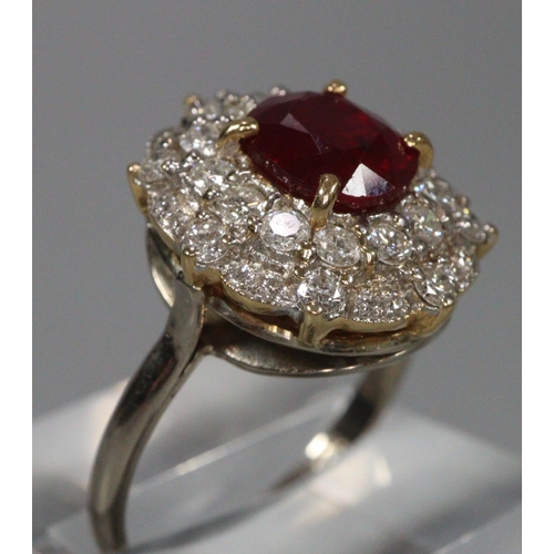 291 - 18ct white gold ruby and diamond ring, the central faceted ruby surrounded by tiny diamonds.  Size R... 