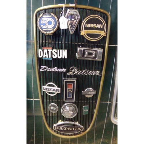 371 - Datsun/Nissan radiator grill set with various Datsun and Nissan vehicle badges, assorted.  Fourteen ... 