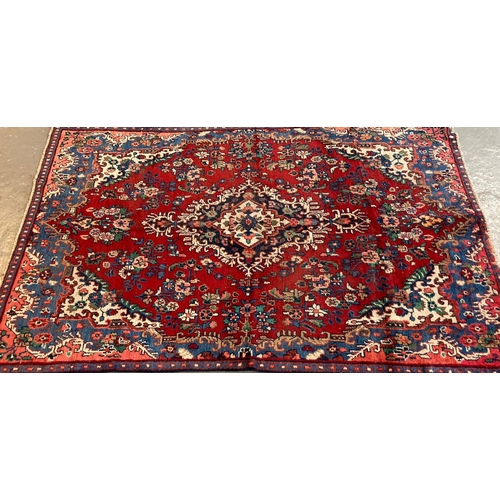 388 - Red ground washed Persian Saruk village rug, with central foliate medallion. 245 x 159cm approx. 
(B... 