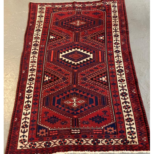 383 - Red ground Persian Hamadan carpet with three lozenge medallions flanked by stylised flowers and foli... 