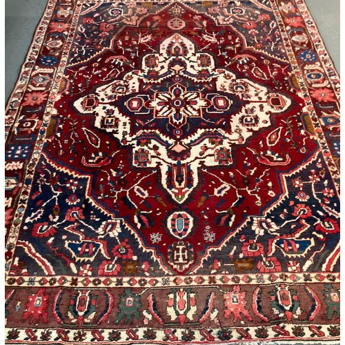 389 - Rich red blue ground Persian Bakhtiari village rug with large central floral and foliate medallion. ... 