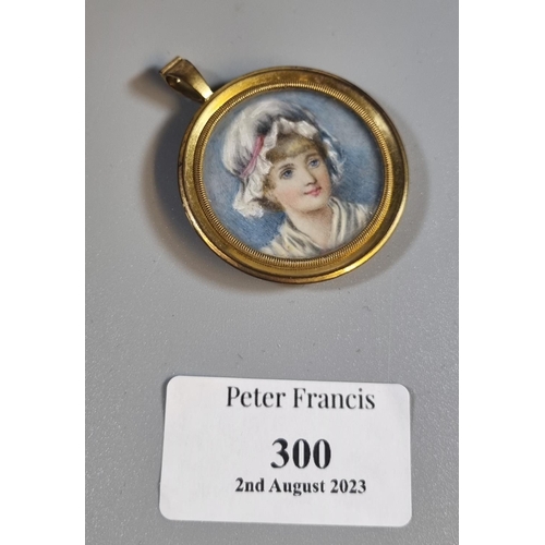 300 - Hand painted portrait pendant of a young girl in bonnet. Gilt metal frame.  (B.P. 21% + VAT)