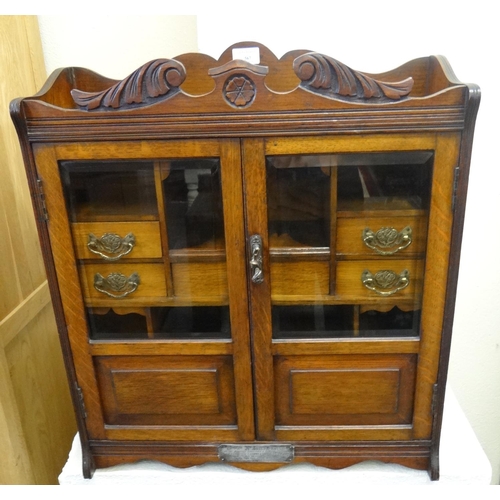 567 - Early 20th century oak two door glazed presentation smokers cabinet with key, the silver plaque date... 