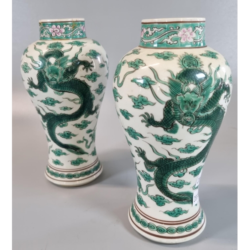 58 - A pair of Chinese porcelain baluster vases, each decorated with two dragons amidst stylised clouds a... 