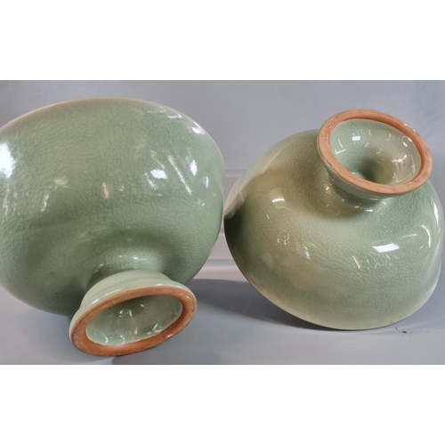 61 - A pair of oriental celadon glazed heavily potted porcelain stem bowls. Impressed marks to bases but ... 