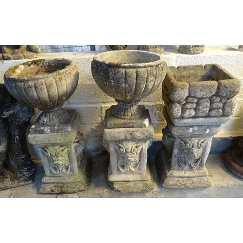 611 - Pair of reconstituted stone garden urns with associated mask pillars together with another planter o... 