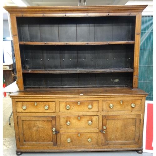 620 - Early 19th century oak North Wales two stage dresser, the moulded cornice above stained boarded rack...