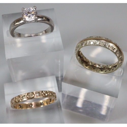 205 - 9ct gold engraved eternity style ring, another similar unmarked, a 9ct white gold solitaire ring.   ... 