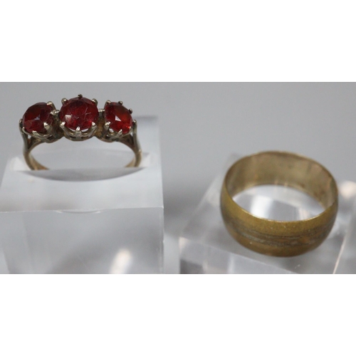 208 - 9ct gold three stone garnet dress ring and a gold plated wedding ring.  (2)  (B.P. 21% + VAT)