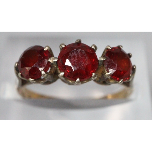 208 - 9ct gold three stone garnet dress ring and a gold plated wedding ring.  (2)  (B.P. 21% + VAT)