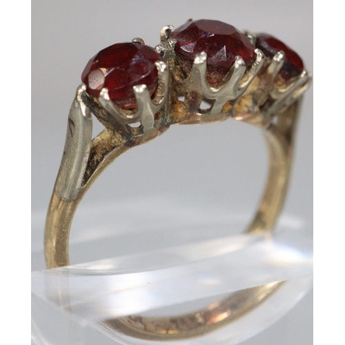 208 - 9ct gold three stone garnet dress ring and a gold plated wedding ring.  (2)  (B.P. 21% + VAT)