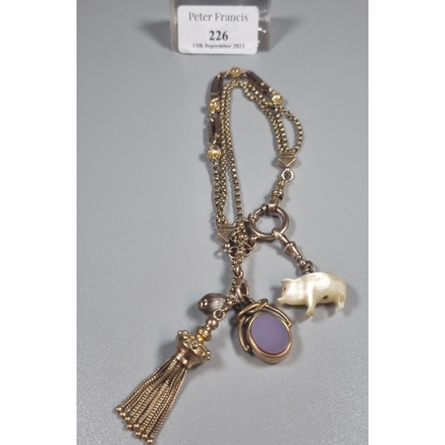 226 - 9ct gold charm bracelet with assorted charms including: tassel, bloodstone fob, mother of pearl pig ...