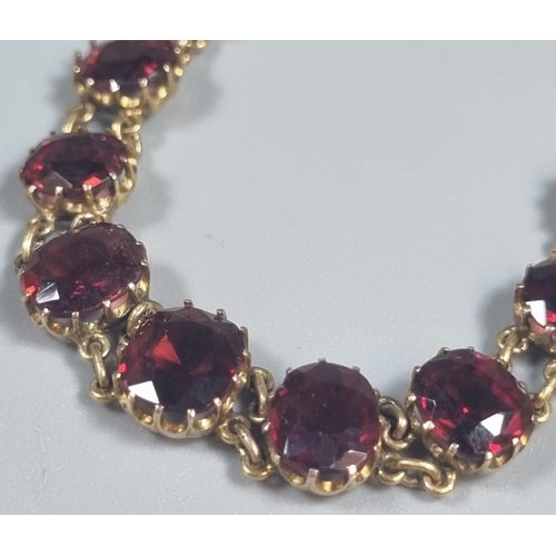 227 - Yellow metal red eleven stone bracelet, probably garnet.  6g approx.   (B.P. 21% + VAT)