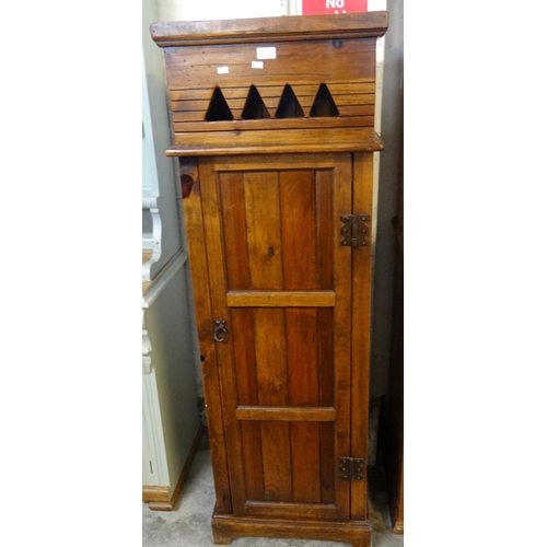 471 - Stained pine tall pedestal cupboard with pierced geometric frieze and panelled door.  50cm wide appr... 